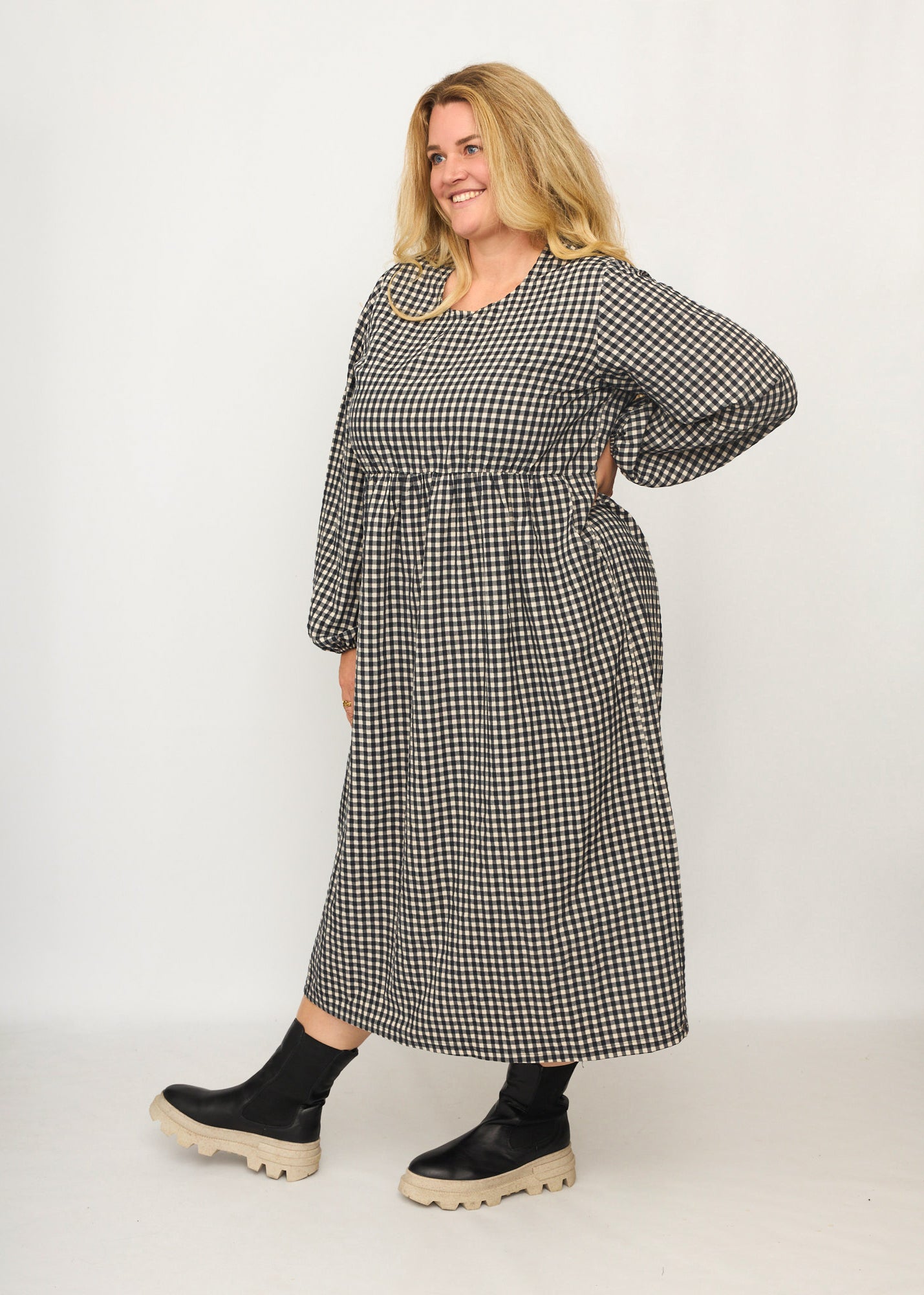 Nina trägt auf dem Foto 'Belinda', Ballonärmel, hohe Taille 5cm weiter unten, Größe 4XL +14 cm am Saum, Seersucker schwarz-creme