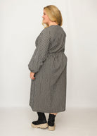 Nina trägt auf dem Foto 'Belinda', Ballonärmel, hohe Taille 5cm weiter unten, Größe 4XL +14 cm am Saum, Seersucker schwarz-creme