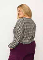 Nina trägt auf dem Foto 'Bella' mit Ballonärmeln Größe XXXL, Seersucker schwarz-creme