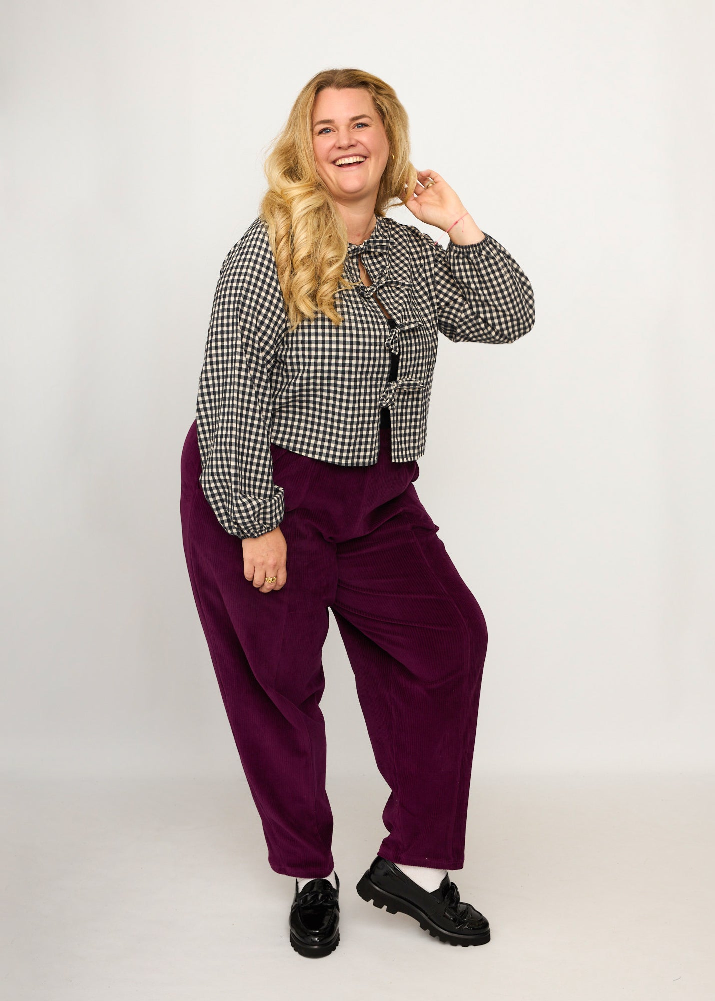 Nina trägt auf dem Foto 'Betty' Größe XXXL, Velvet-Cord aubergine und 'Bella' mit Ballonärmel Größe XXXL, Seersucker schwarz-creme