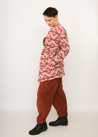 Melly trägt auf dem Foto 'Cora' Größe S, Muster elastisch, Jacquardstrick Pink-rot und 'Betty' Größe M, Velvet-Cord rostrot