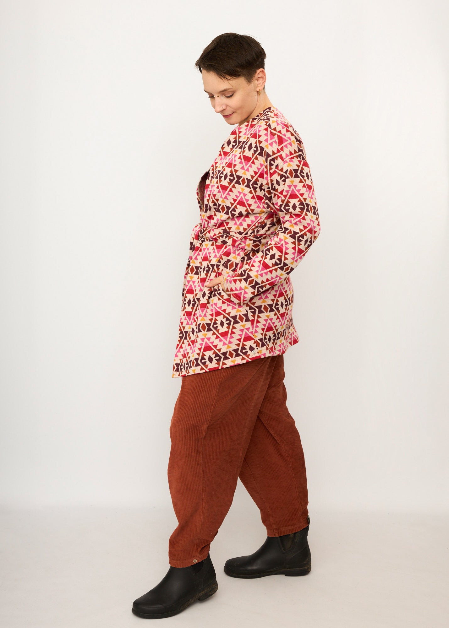 Melly trägt auf dem Foto 'Cora' Größe S, Muster elastisch, Jacquardstrick Pink-rot und 'Betty' Größe M, Velvet-Cord rostrot