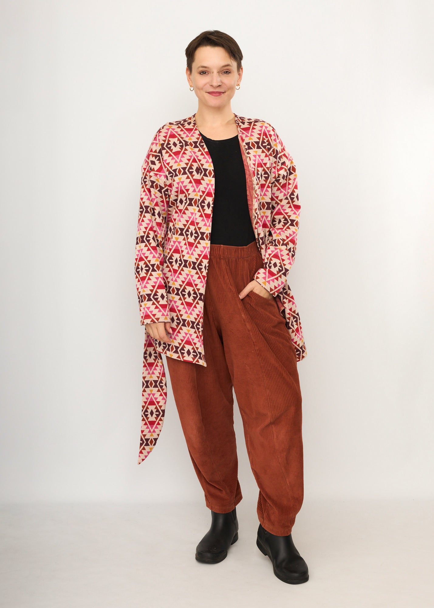 Melly trägt auf dem Foto 'Cora' Größe S, Muster elastisch, Jacquardstrick Pink-rot und 'Betty' Größe M, Velvet-Cord rostrot