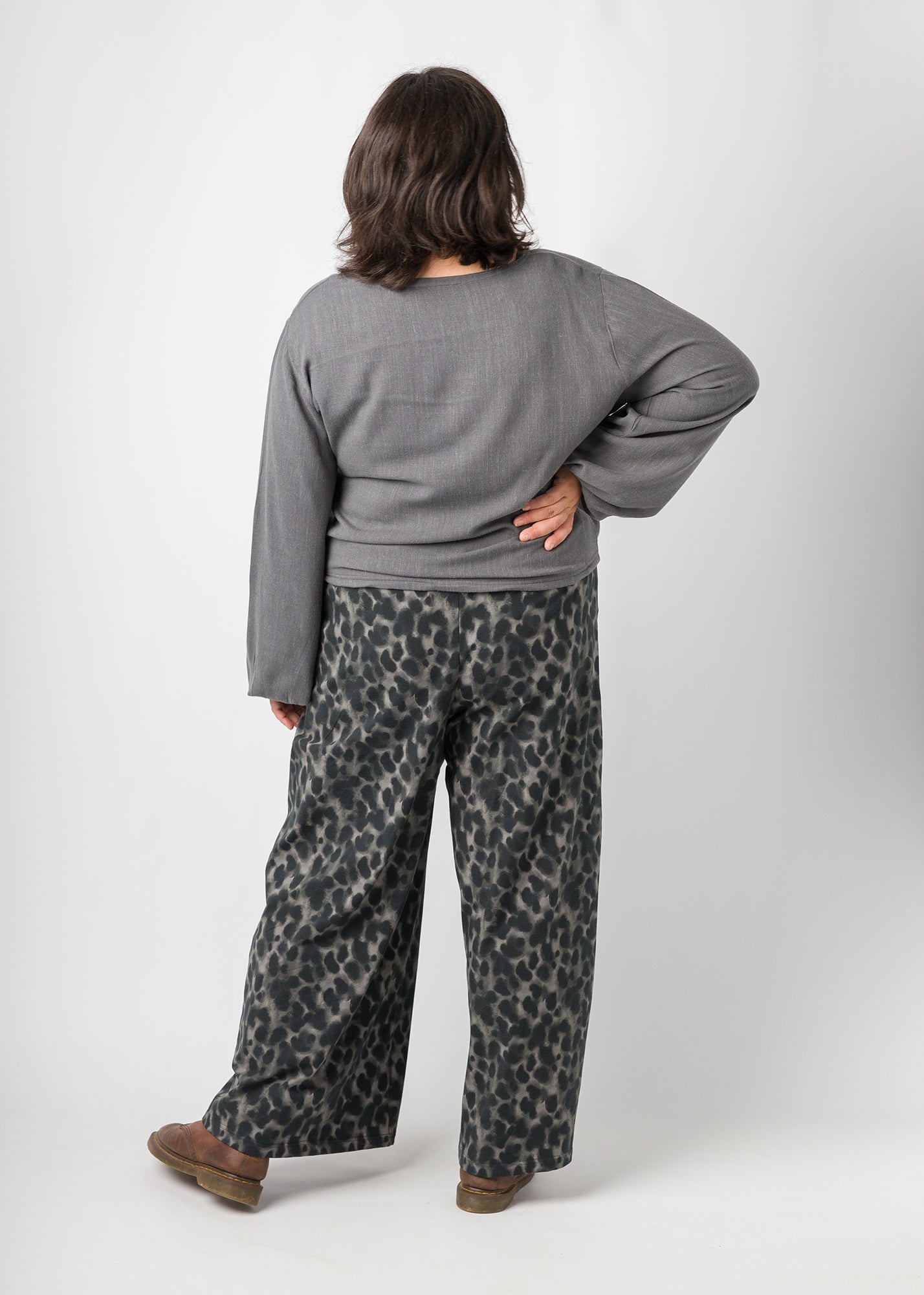 Flores trägt auf dem Foto 'Greta' mit Ballonärmel Größe XL, EcoVeroLeinen grau und 'Holly' weites Bein Größe XXL, Muster elastisch 'Dark Leobert'