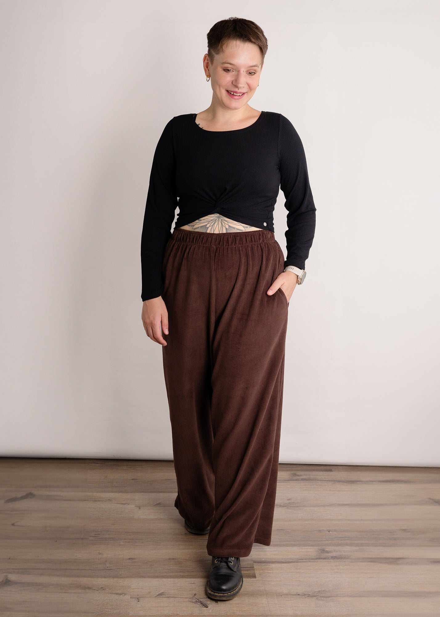 Melly trägt auf dem Foto 'Marlene' Größe M, Velvet-Cord braun und 'Clara' Größe M, Rippjersey schwarz