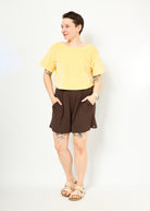 Melly trägt hier Gerda Velvet gelb in Größe M & die kurze Hose Kira in braun Größe M