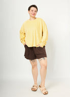 Melly trägt hier Regina Größe XL in gelb und Kira kurze Hose in Rippjersey braun Größe M