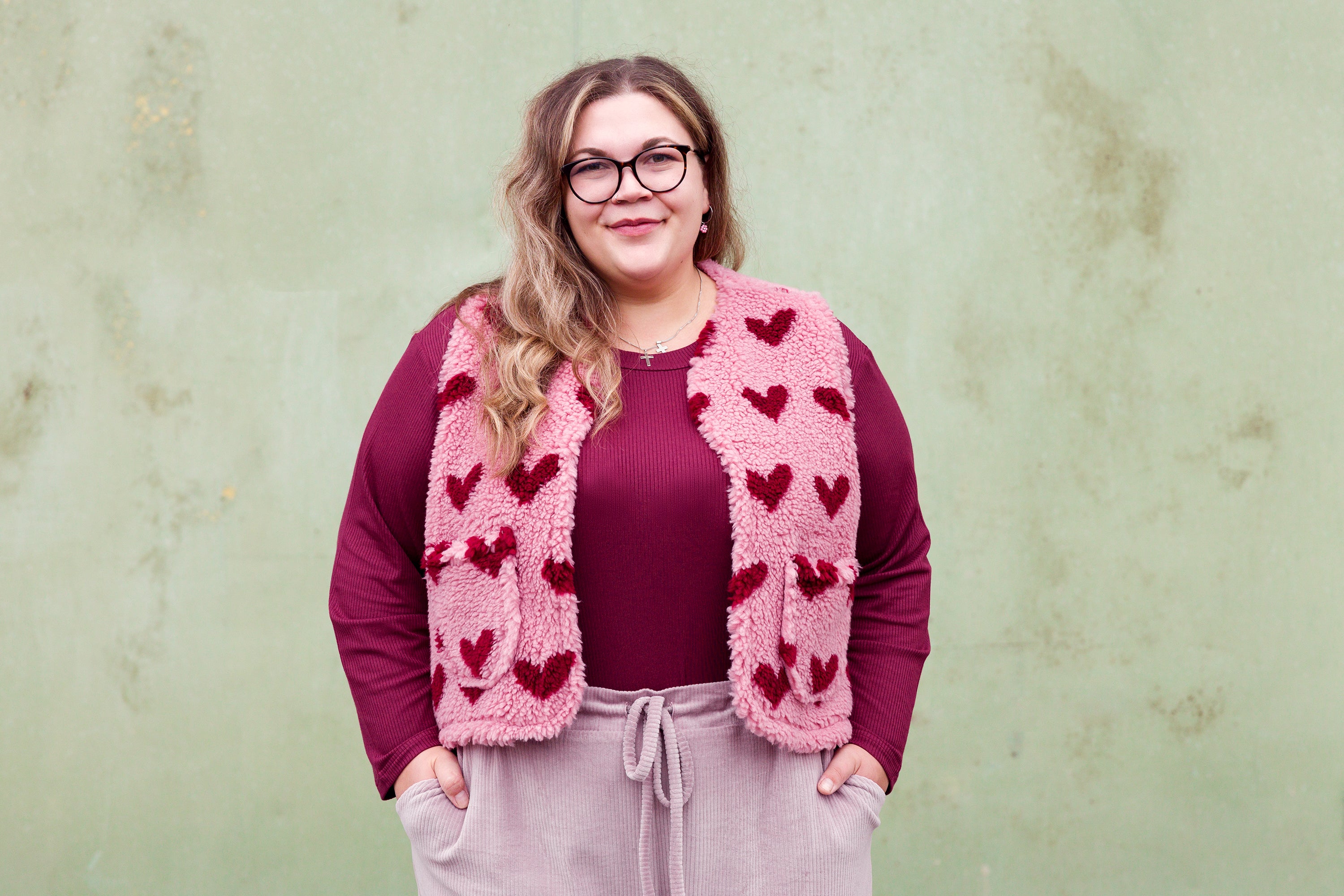 Vroni trägt auf dem Foto 'Theo' Größe 4XL, Rippjersey burgund und 'Waltraut' mit Taschen Größe 4XL/5XL, Muster Plüsch 'Herzchen rosa-rot'