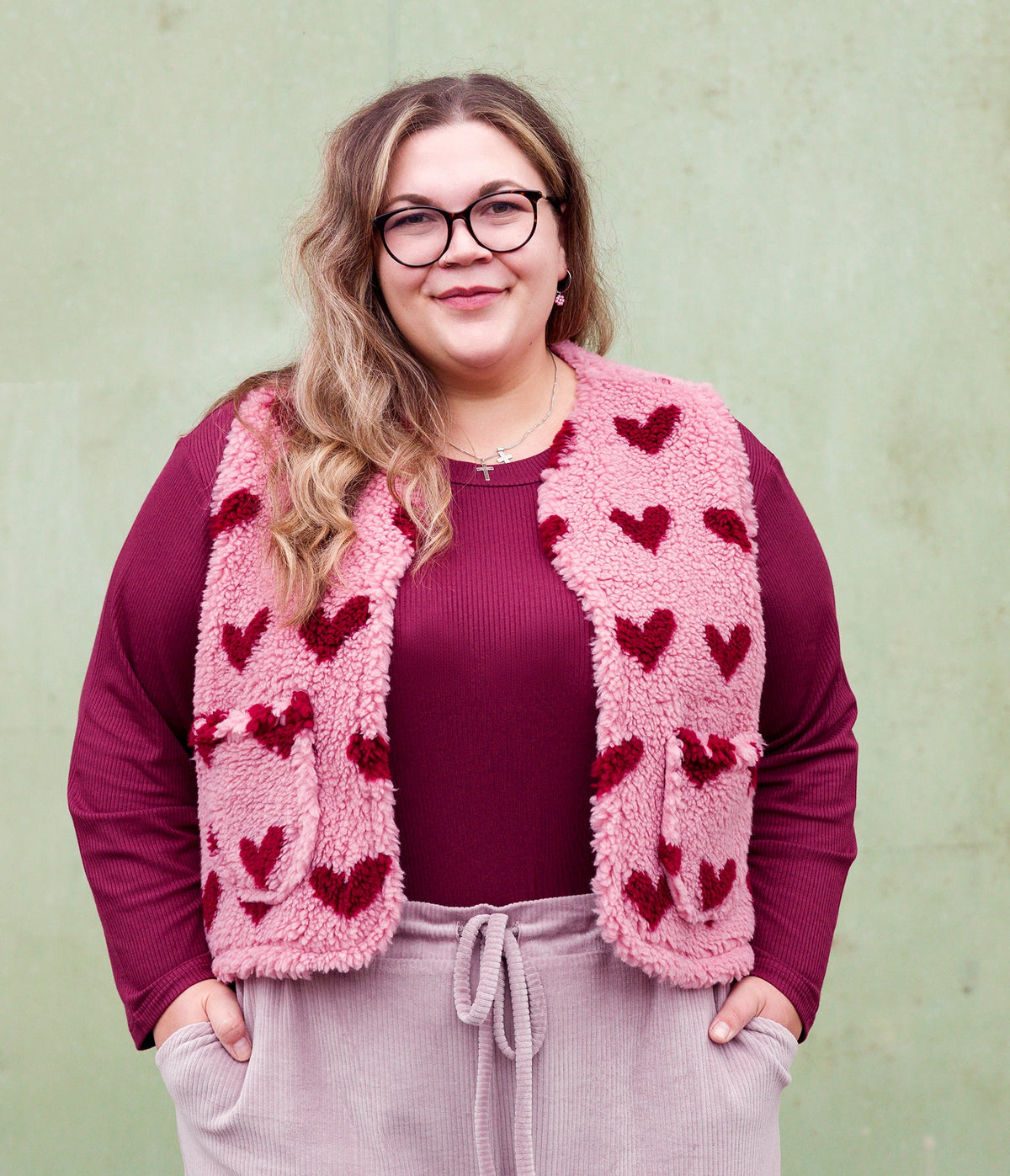 Vroni trägt auf dem Foto 'Theo' Größe 4XL, Rippjersey burgund und 'Waltraut' mit Taschen Größe 4XL/5XL, Muster Plüsch 'Herzchen rosa-rot'