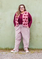 Vroni trägt auf dem Foto 'Theo' Größe 4XL, Rippjersey burgund, 'Waltraut' mit Taschen Größe 4XL/5XL, Muster Plüsch 'Herzchen rosa-rot' und 'Holly' schmales Bein Größe 4XL, Velvet-Cord flieder