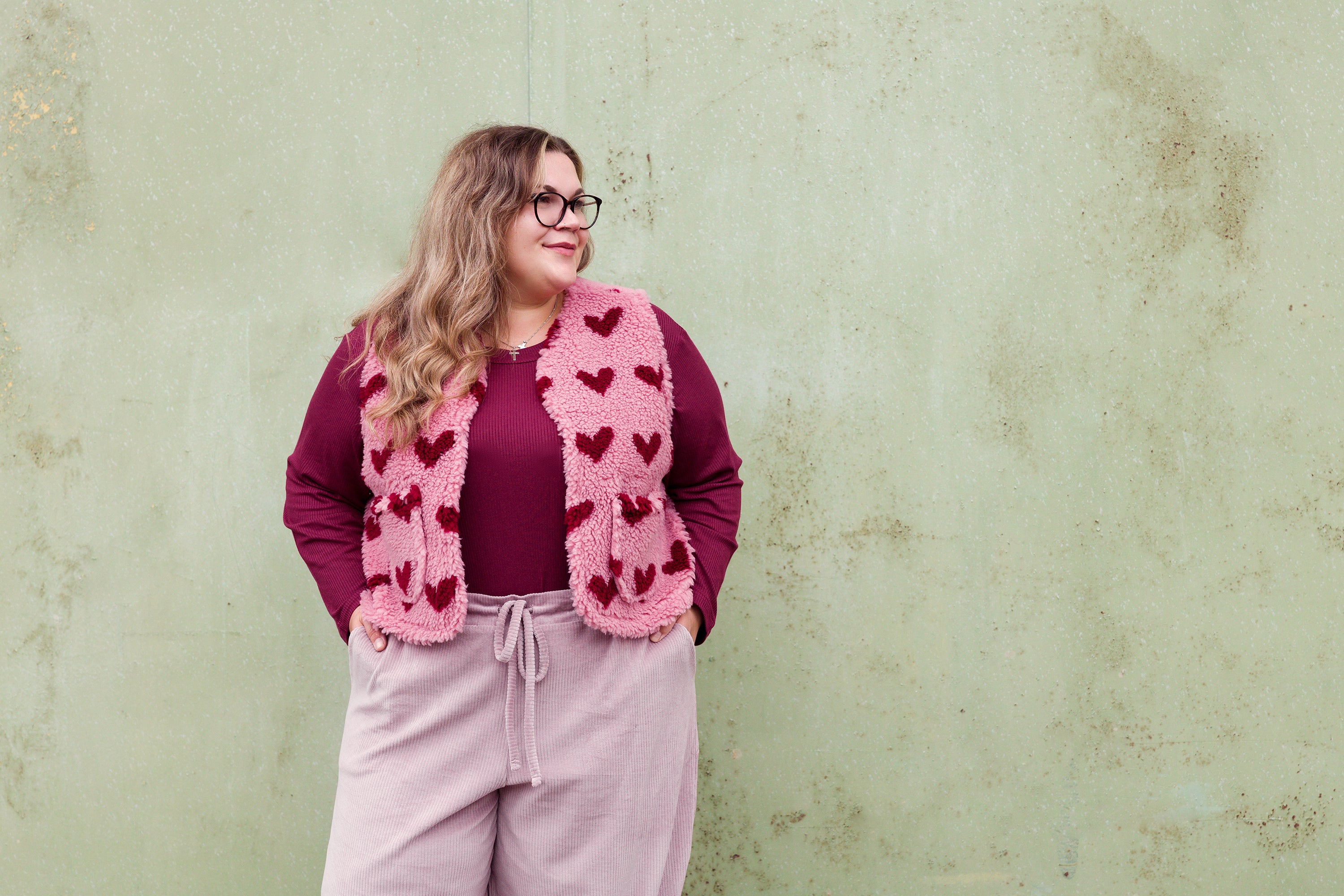 Vroni trägt auf dem Foto 'Theo' Größe 4XL, Rippjersey burgund, 'Waltraut' mit Taschen Größe 4XL/5XL, Plüsch 'Herzchen rosa-rot' und 'Holly' schmales Bein Größe 4XL, Velvet-Cord flieder