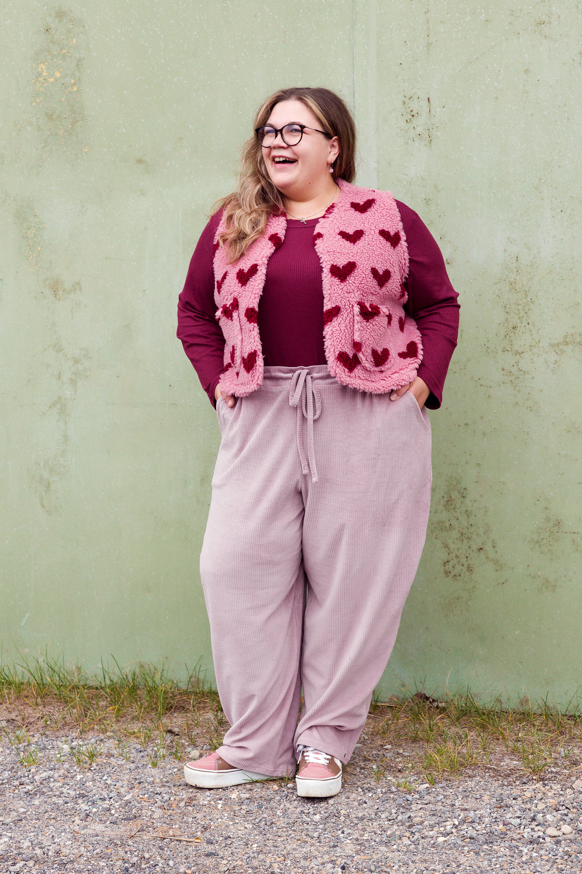 Vroni trägt auf dem Foto 'Theo' Größe 4XL, Rippjersey burgund, 'Waltraut' mit Taschen Größe 4XL/5XL, Muster Plüsch 'Herzchen rosa-rot' und 'Holly' schmales Bein Größe 4XL, Velvet-Cord flieder